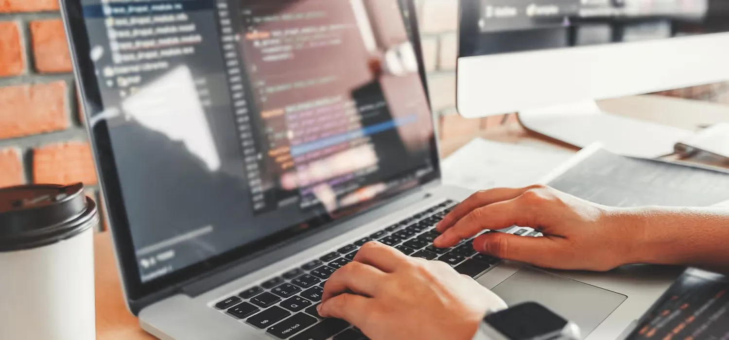 Un développeur devant son pc occupée à coder une application front-end et back-end